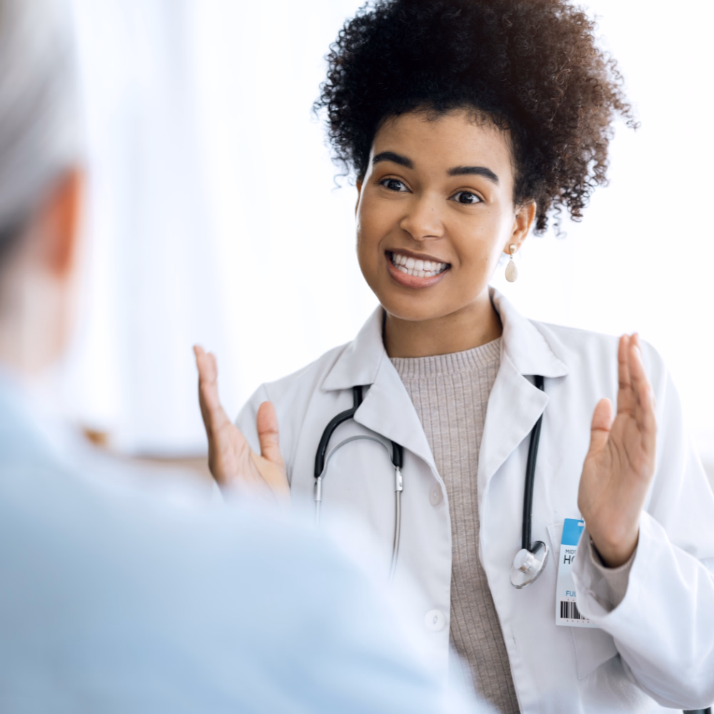 Friendly Doctor Discusses Health With Patient In Clinic