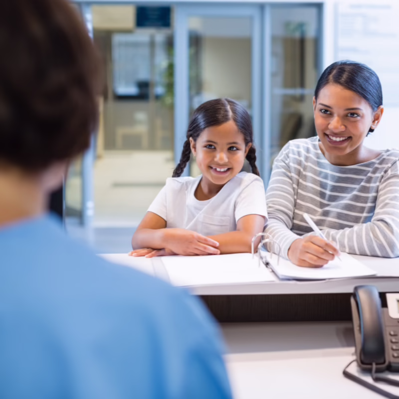 Healthcare professional discussing medical paperwork with a mother and child