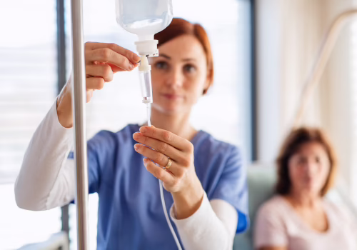 Nurse preparing an IV drip for a patient receiving infusion therapy