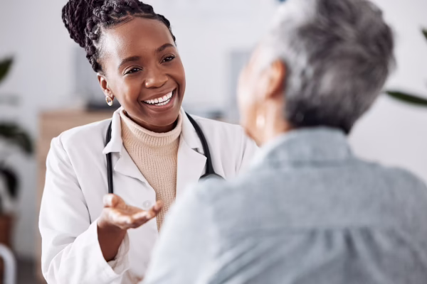 Smiling Doctor Talking With Senior Patient In Office