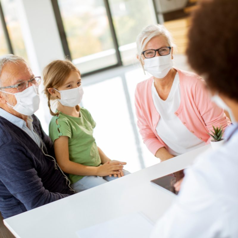 Healthcare professional discussing medical care with a patient and her family